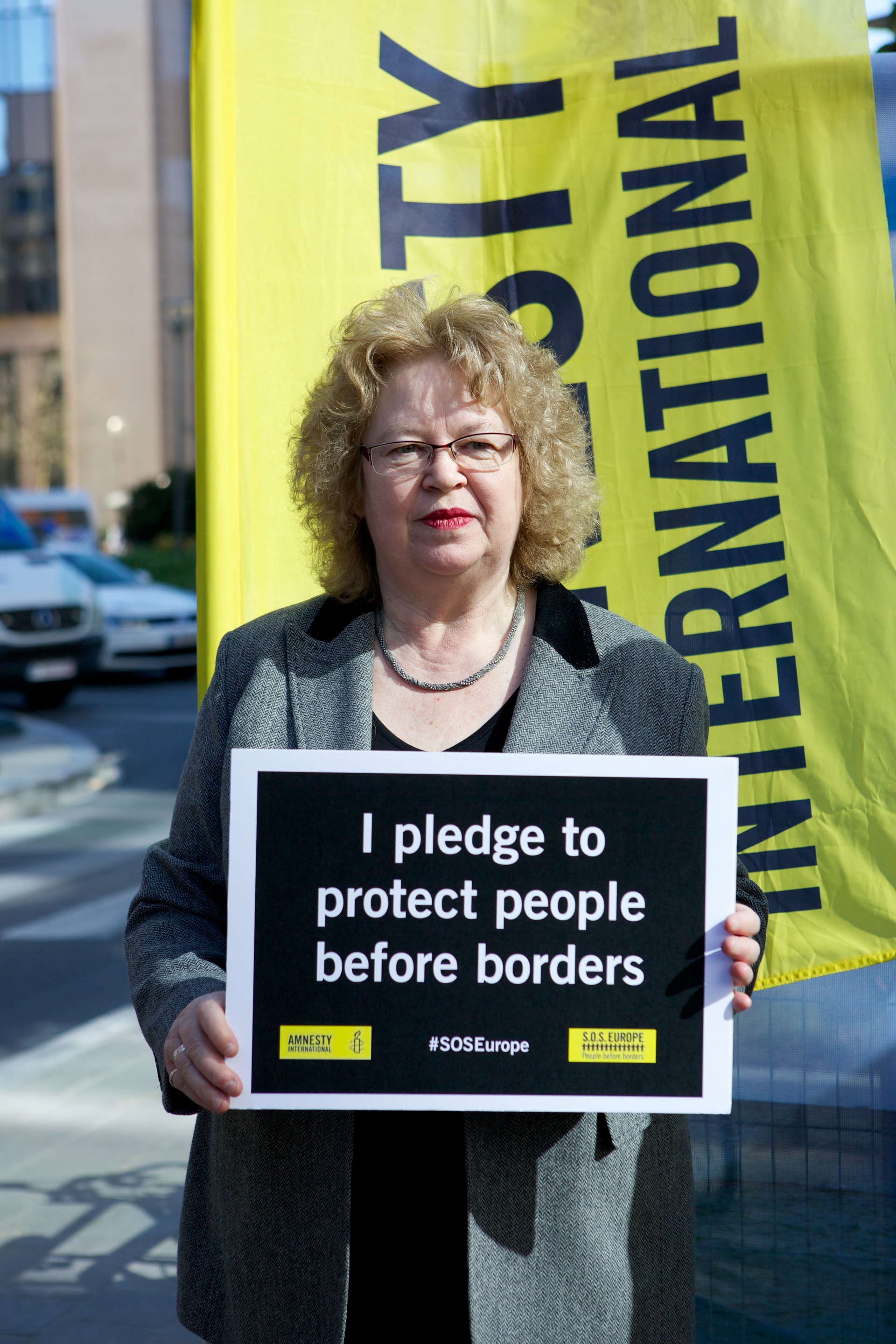 Jean holding borders action sign, pledging to protect people above borders